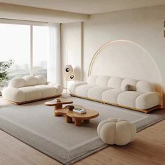 a living room with white furniture and large windows