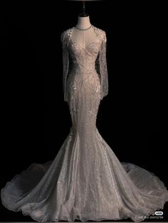 a white wedding dress on display in front of a black background