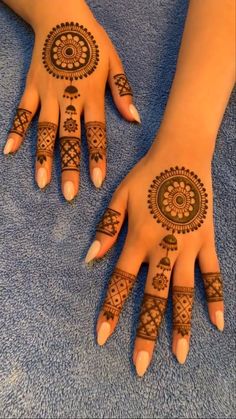 two hands with henna tattoos on them