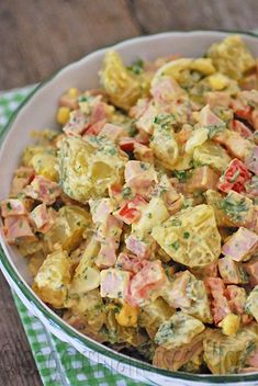 a bowl filled with potato salad on top of a green and white checkered cloth