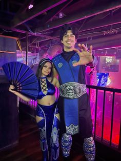 a man and woman in costume posing for the camera