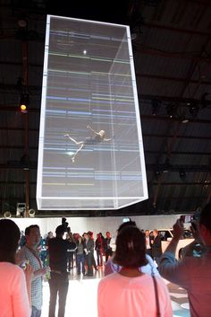 a group of people standing in front of a projector screen with an image on it