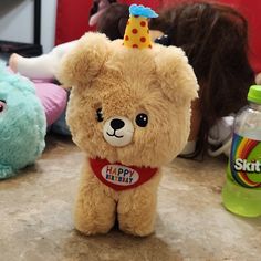 a brown teddy bear wearing a birthday hat