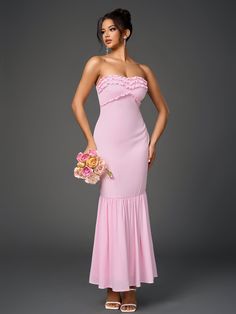 a woman in a pink dress is holding a flower bouquet and posing for the camera