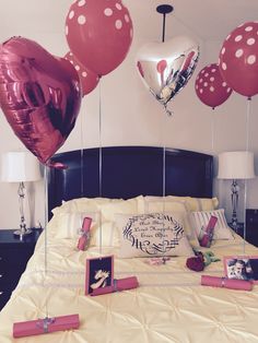 balloons are floating in the air above a bed