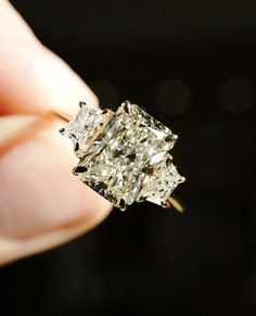 a woman's hand holding an old diamond ring