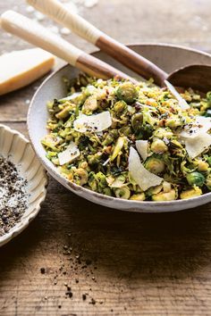 a bowl filled with food next to two wooden spoons