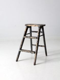 an old wooden step stool sitting on top of a white floor