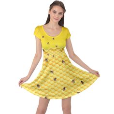 a woman wearing a yellow dress with bees on it