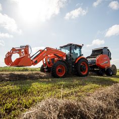 an orange tractor is parked in the middle of a field