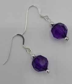 The earrings are made with a single round purple crystal bead and silver seed beads.  Earrings hang a total of 1 1/2 inches in length and have a sterling silver earring wire. Nickel Free Sterling Silver Beaded Earrings, Nickel-free Round Sterling Silver Beaded Earrings, Sterling Silver Round Bead Crystal Earrings, Adjustable Sterling Silver Beaded Crystal Earrings, Sterling Silver Beaded Crystal Earrings, Purple Beaded Sterling Silver Jewelry, Beaded Sterling Silver Drop Earrings, Sterling Silver Beaded Earrings, Sterling Silver Crystal Earrings With Round Beads As Gift