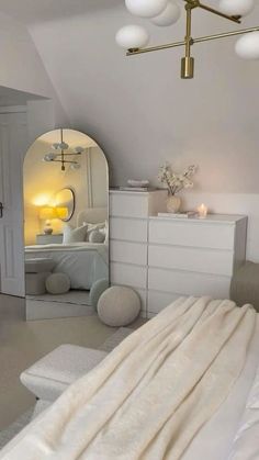 a bedroom with white furniture and lots of lights on the ceiling, along with an arched doorway leading to another room