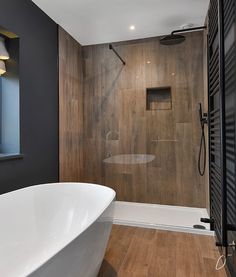 a white bath tub sitting next to a walk in shower