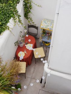 an overhead view of a table and chairs on a small patio with potted plants