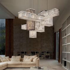 a living room filled with furniture and a chandelier hanging over the top of it