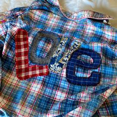 a blue and red plaid shirt with the letter e on it