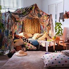 a bedroom with a canopy bed and lots of pillows on the floor in front of it