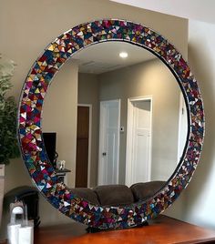 a mirror that is sitting on top of a wooden table in front of a couch