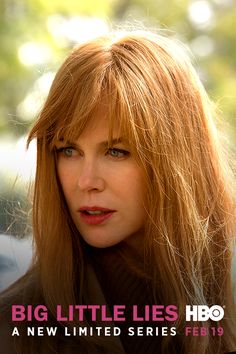 a woman with long red hair is looking at the camera