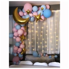 a balloon arch with stars, moon and balloons on the wall in front of a window