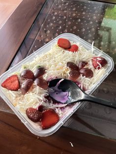 a plastic container filled with fruit and cheese