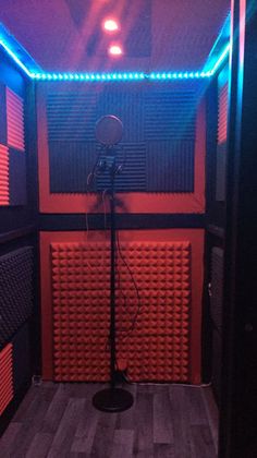 an empty room with several microphones and lights on the walls, in front of a sound board