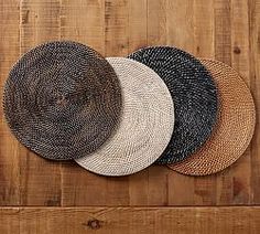 four hats are arranged on a wooden surface