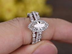 a person holding an engagement ring with diamonds on it's sides and the center diamond in