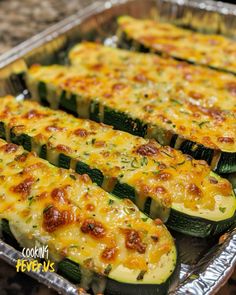 cooked zucchini slices with cheese and seasoning in a metal pan on a counter