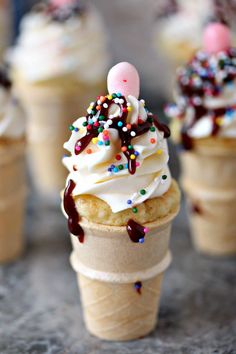 an ice cream cone with sprinkles and candy on top