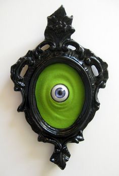 a black and green object with an eye in the center