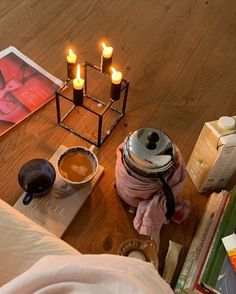 candles are lit on a table with books and other items