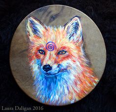 a painting of a red fox with blue eyes on a round plate, sitting on black fur