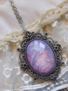 JUST LISTED - Vintage Inspired - Georgian & Victorian Cameo Jewlery - Lavender purple Moonstone FIre Opal OOAK Victorian princess Fantasy glass art Mythical Necklace Altered Art substantial in size at just a little over 2 INCHES Long Center is 40mmx30mm **thank you for taking the time to look at our items. Each item is handcrafted and attention to detail - We send each item in bubble packaging and with tracking to make sure items arrive in perfect condition. Please feel free to check out our Handmade Purple Fantasy Necklaces, Handmade Purple Fantasy Necklace, Purple Fantasy Necklace For Gift, Fantasy Style Purple Necklace For Gift, Artistic Purple Pendant Jewelry, Magical Purple Pendant Necklace, Purple Handmade Magical Jewelry, Handmade Magical Purple Jewelry, Artistic Round Purple Jewelry