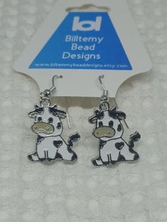 the earrings are shaped like a cow