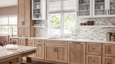 a kitchen filled with lots of wooden cabinets and counter top space next to a window