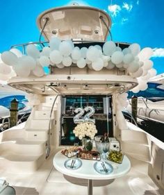 a table with balloons on it in the middle of a room filled with yachts