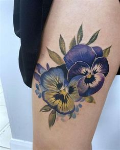 a woman's thigh with blue and yellow flowers on it