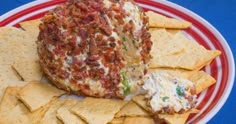 a red and white plate with crackers, tortilla shells and cheese on it