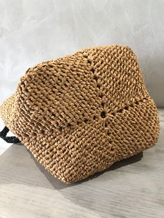 a straw bag sitting on top of a wooden table