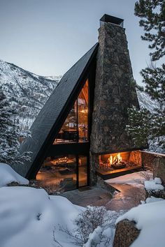 a large stone building with a fireplace in the middle of it's roof and snow on the ground