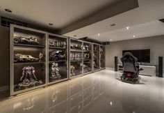 a room filled with lots of different types of toys and vehicles in glass cases on the wall