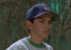 a young man wearing a baseball cap and looking off to the side