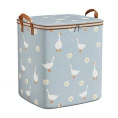 a large blue box with white ducks and daisies on the front, sitting in front of a white background