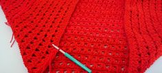 two crocheted red shawls are laying next to each other