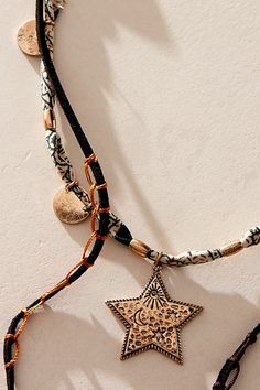 Get that effortlessly layered look with this multi-strand necklace, featured in a mixed-material design with a cascading lariat, beaded accents, and star pendants. **Features:** Layered style, lariat design, suede and textile chains, knotted details, mixed beads, star pendants, adjustable clasp closure | Dandelion Lariat Necklace by Free People in Black Bohemian Necklace With Star Charm For Festivals, Bohemian Star Charm Necklace For Festivals, Bohemian Festival Necklaces With Star Charm, Festival Multi-strand Layered Necklace, Bohemian Star Jewelry For Festivals, Bohemian Star-shaped Jewelry For Festivals, Bohemian Star-shaped Festival Jewelry, Bohemian Jewelry With Star Charm, Gold Lariat Necklace