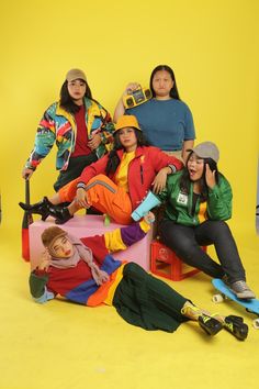 the group of people are posing together on their skateboards in front of a yellow background