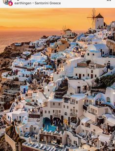 an aerial view of the white houses and windmills in oia, greece at sunset