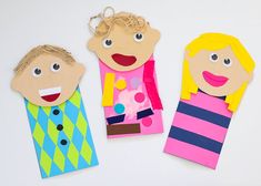 three children's puppets made out of paper with faces on them, one is blonde and the other is blue