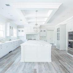 a large kitchen with white cabinets and an island